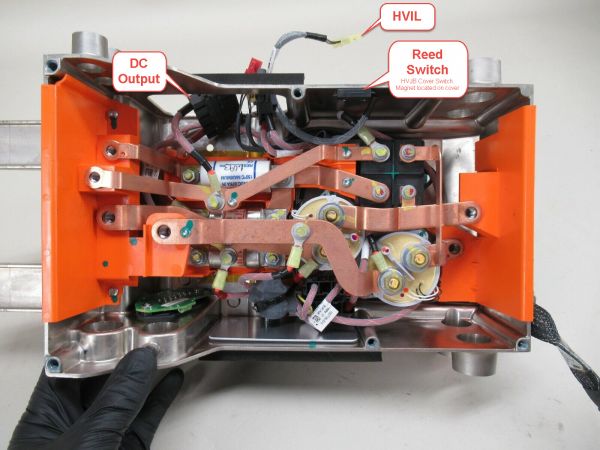 Tesla Model S GEN1 HVJB (under rear seat), lid removed, showing the HVIL cover reed switch and HVIL connector that connects to a mating connector on the OBC.